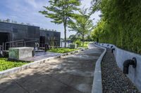 the walkway around a building in an urban area, is lined with plants and trees