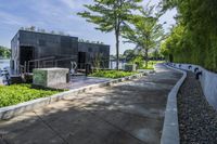 the walkway around a building in an urban area, is lined with plants and trees