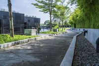 the walkway around a building in an urban area, is lined with plants and trees