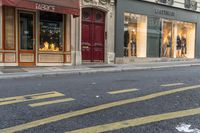 a man wearing jeans walks down the street and a yellow fire hydrant is in front of a shop