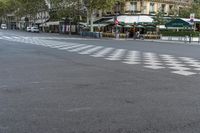 a street with checkerboard on it in front of two buildings and umbrellas