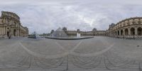 a view of the courtyard outside of a museum with sculptures and some glass buildings surrounding