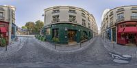 a panoramic image shows the street with old buildings in front of them and a green cafe in the middle