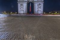 the arc de trio triumph with red fire hydrants in foreground at night time