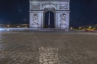 the arc de trio triumph with red fire hydrants in foreground at night time