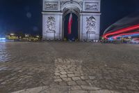 the arc de trio triumph with red fire hydrants in foreground at night time