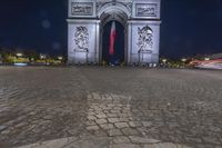 the arc de trio triumph with red fire hydrants in foreground at night time