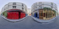 360 - lens photograph shows red doors on white buildings along the street in front of them