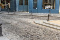 a street corner with a blue building and a stop sign in front of it in paris