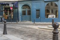 a street corner with a blue building and a stop sign in front of it in paris