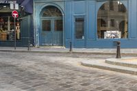 a street corner with a blue building and a stop sign in front of it in paris