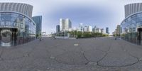 an empty street with two circular mirrors in the middle of it and some very tall buildings in the background