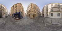 a fisheye lens is on the street in front of buildings and a restaurant with tables on the sidewalk