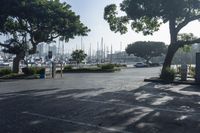 a park bench and parking meters in front of boats in a marina district area with a sign reading