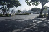 a park bench and parking meters in front of boats in a marina district area with a sign reading