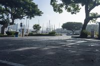 a park bench and parking meters in front of boats in a marina district area with a sign reading