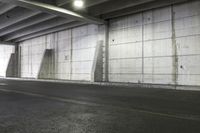 a car is parked in an empty parking garage next to a brick wall and street