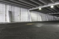 a car is parked in an empty parking garage next to a brick wall and street