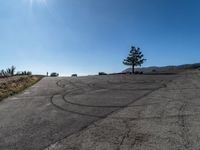 cars parked on the side of a hill in a circle with the sun shining down