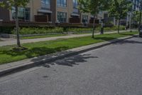 parked cars are on the street next to the houses and trees and a blue sky with white clouds