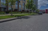 parked cars are on the street next to the houses and trees and a blue sky with white clouds