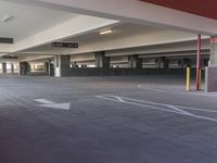 a parking garage is shown with an arrow painted on the floor and some signs pointing to the left