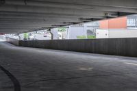 the empty street under the pedestrian bridge in an urban area, looking down the street