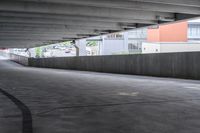 the empty street under the pedestrian bridge in an urban area, looking down the street