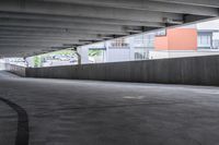 the empty street under the pedestrian bridge in an urban area, looking down the street