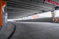 the empty street under the pedestrian bridge in an urban area, looking down the street