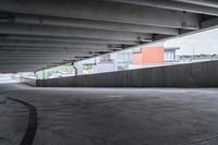 the empty street under the pedestrian bridge in an urban area, looking down the street