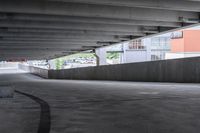 the empty street under the pedestrian bridge in an urban area, looking down the street