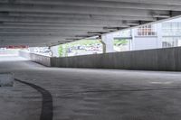 the empty street under the pedestrian bridge in an urban area, looking down the street