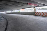 the empty street under the pedestrian bridge in an urban area, looking down the street