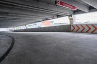 the empty street under the pedestrian bridge in an urban area, looking down the street