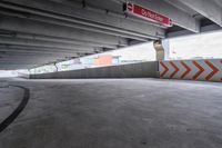 the empty street under the pedestrian bridge in an urban area, looking down the street