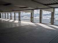 an empty commercial warehouse with a lot of windows and steel walkways through it,