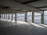 an empty commercial warehouse with a lot of windows and steel walkways through it,