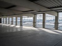 an empty commercial warehouse with a lot of windows and steel walkways through it,