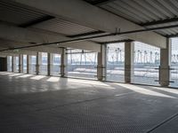 an empty commercial warehouse with a lot of windows and steel walkways through it,