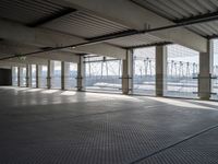 an empty commercial warehouse with a lot of windows and steel walkways through it,