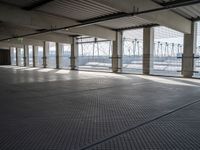 an empty commercial warehouse with a lot of windows and steel walkways through it,