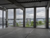 a view of an empty building from a glass walkway at the top of it and through the columns