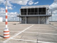 parking lot at an airport with white and red markings in a parking lot in front of a control tower