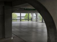 an underground parking lot with a green arrow sign in the middle of the road on a flat surface