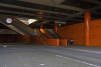 an empty parking garage with escalators and some stairs and one is empty, so that has no people on them