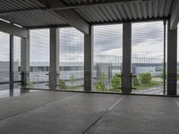 an indoor room with floor to ceiling glass and grey tile floors with large windows on the left