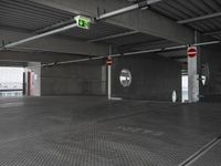 parking garage with no doors and sign and no parking symbol on floor for passengers in