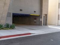 the empty entrance to the parking garage is shown from behind it and on one side there are trees