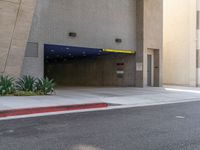 the empty entrance to the parking garage is shown from behind it and on one side there are trees